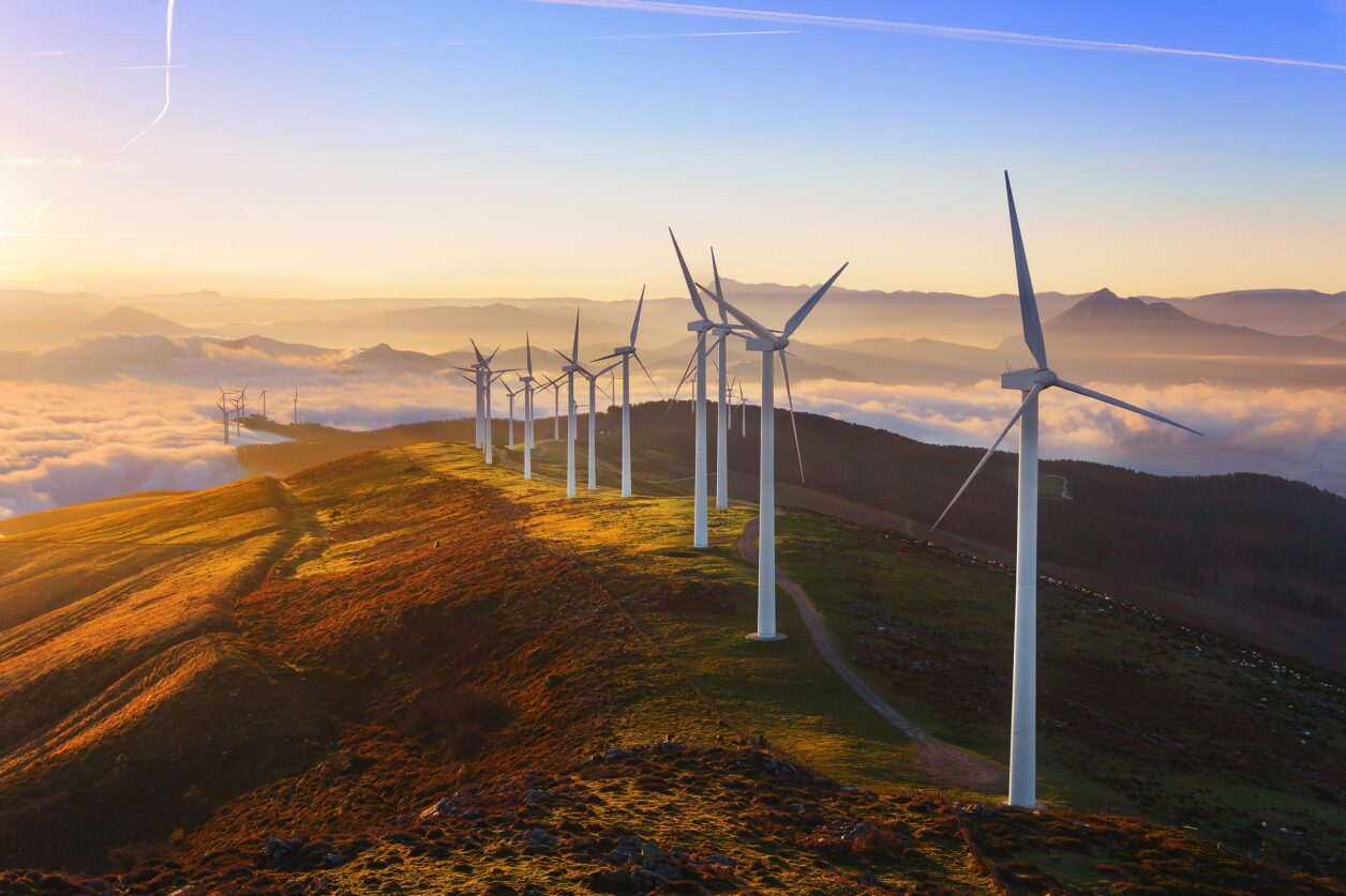 Wind turbines along top of hill above small town
