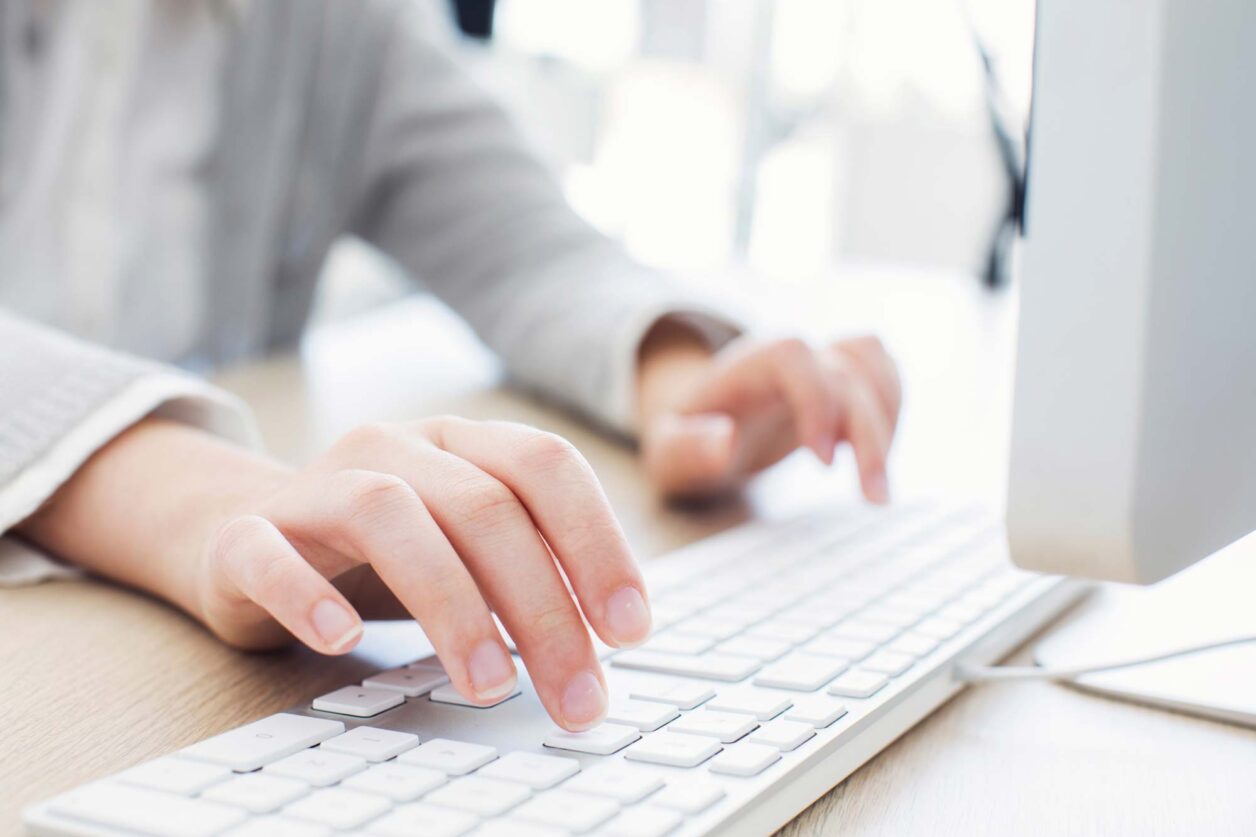 Person typing on keyboard at desk