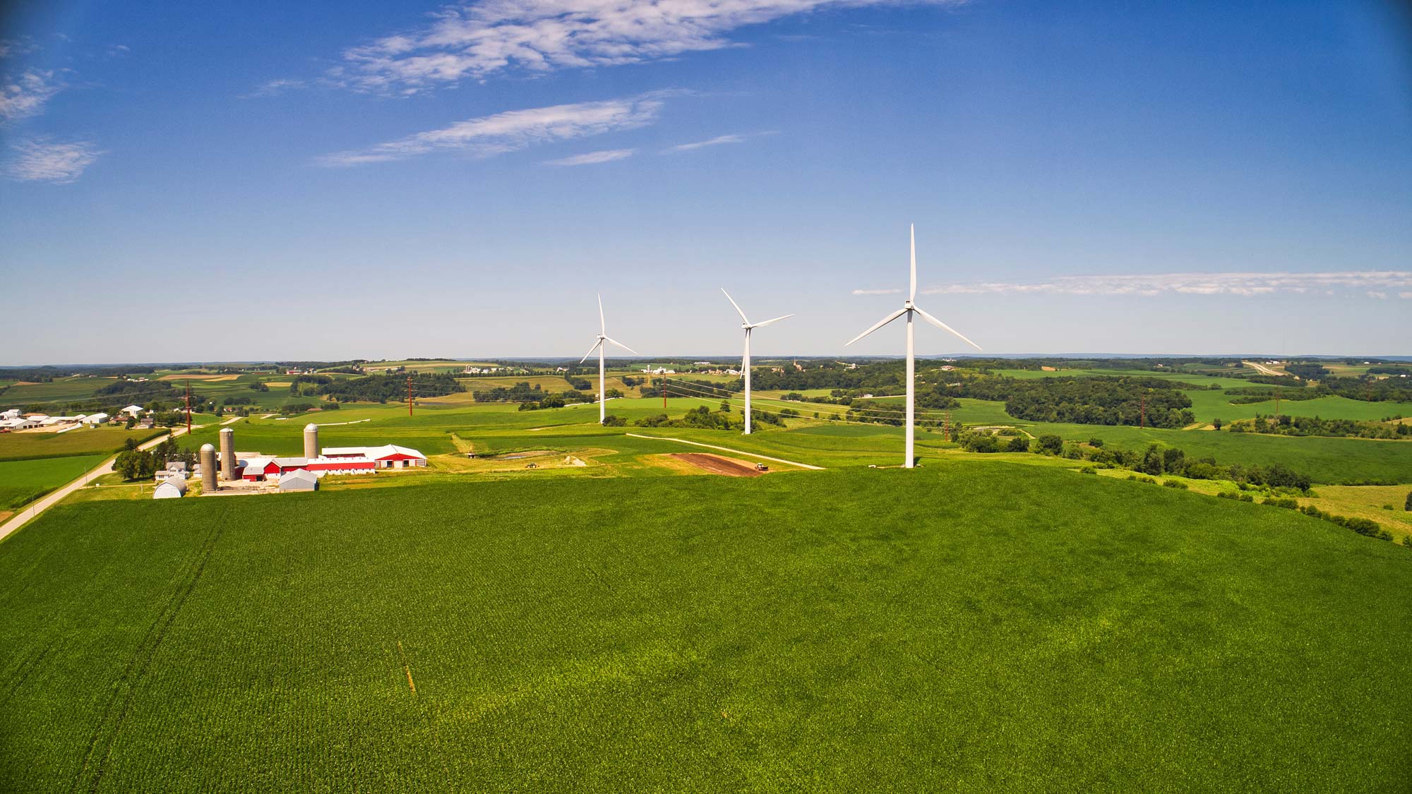 Small scale wind farm with three turbines near established traditional farm