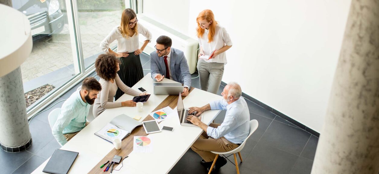 Group of office professionals gathered around a conference table