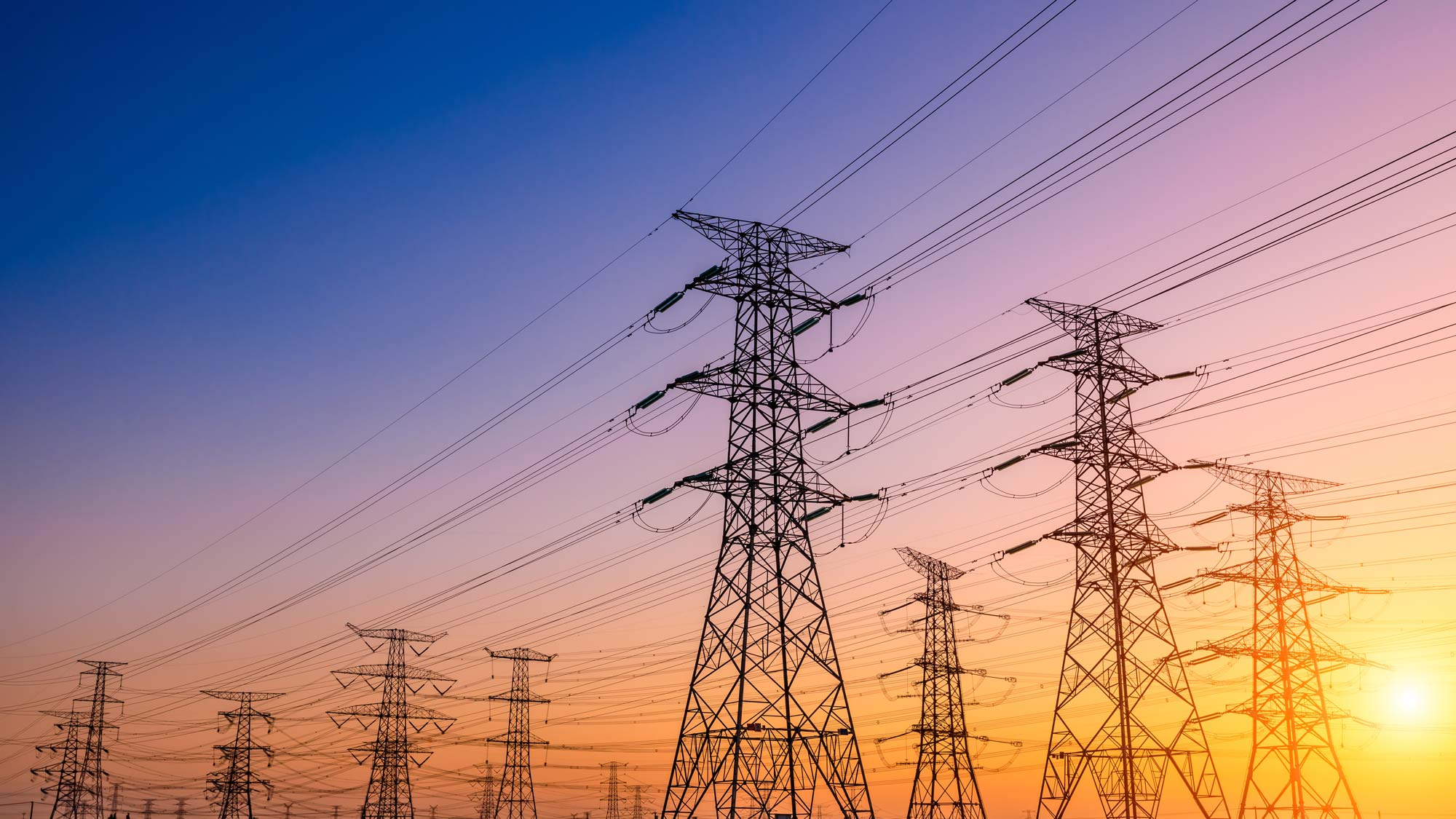 High voltage electricity transmission power lines at sunset