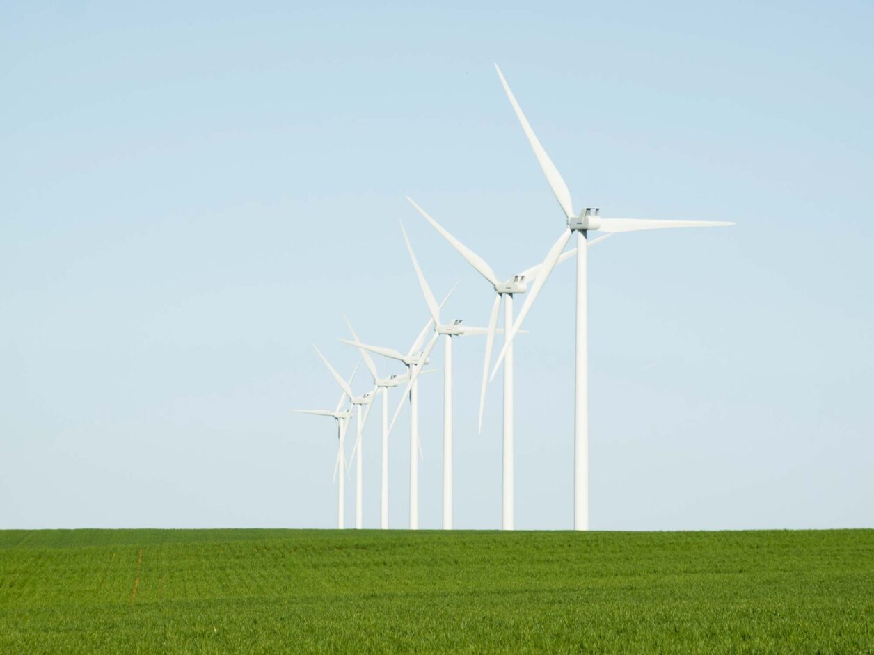 Smart rural connectivity wind turbines lined up in an agriculture field