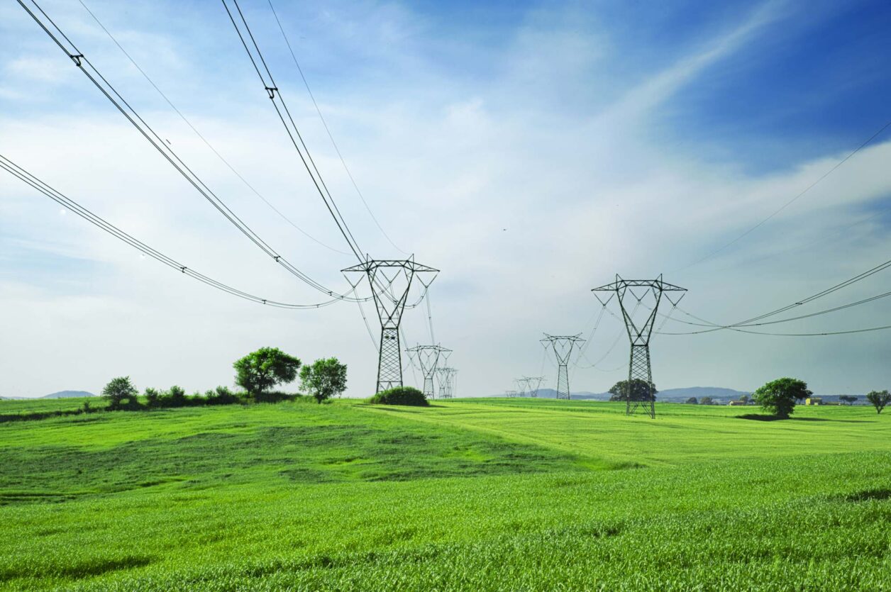 Power lines between transmission towers stretch across rural Midwest